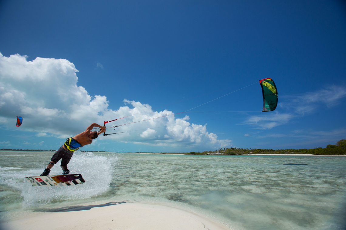 Kiteboarder Youri Zoon popping a jump over a tropical sandbar on his Best Kiteboarding gear.