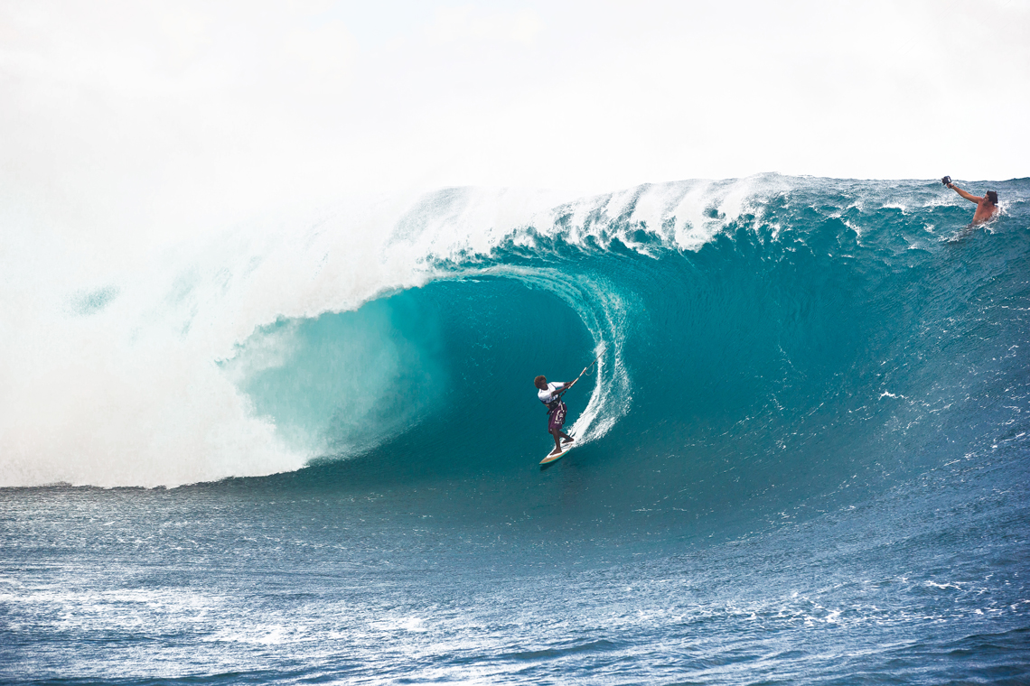 Mitu Monteiro on a huge day at Teahupoo, surfing wave, taking time for camera