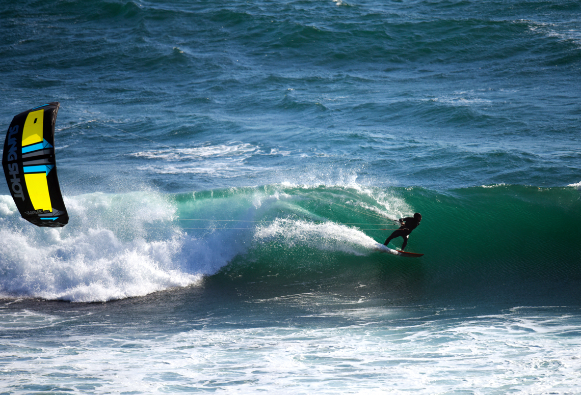 A kitesurfer riding a wave on the 2016 Slingshot Wave SST kite.