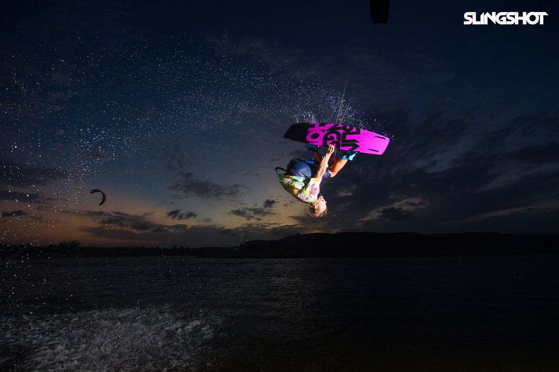 Sam Light on the 2015 Slingshot asylum board. Inverted with a grab kitesurfing.