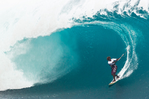 Mitu Monteiro on a huge day at Teahupoo, surfing wave, taking time for camera