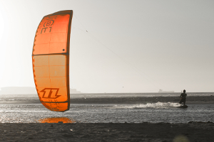 A kitesurfer cruising on the 2015 North kiteboarding Juice kite around sunset in light winds.