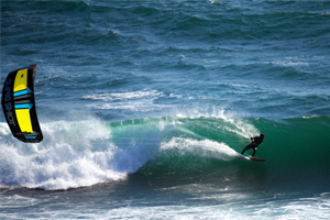 A kitesurfer riding a wave on the 2016 Slingshot Wave SST kite.